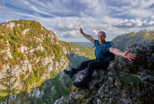 istock Man on a cliff in the mountains 1285865580