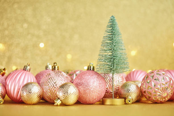 istock Glittering Christmas Background with Pink and Gold Decorations and Christmas Tree 1285867150