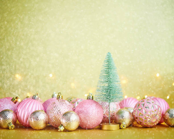 istock Glittering Christmas Background with Pink and Gold Decorations and Christmas Tree 1285867188