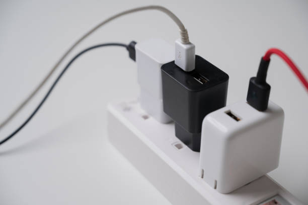 istock Electric adapter smartphone plug in multiple socket. Electrical equipment, electrical wires and power strips in the house. Earth Hour saving electrical energy. 1285868870