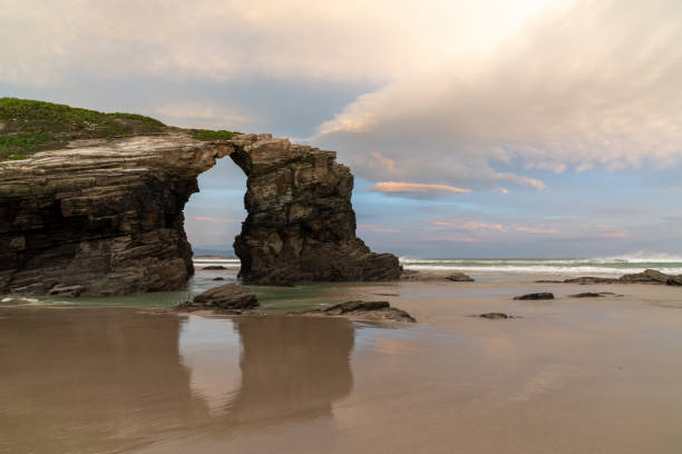 istock beautiful beach with fine sand and rocky cliffs at sunrise 1285873589