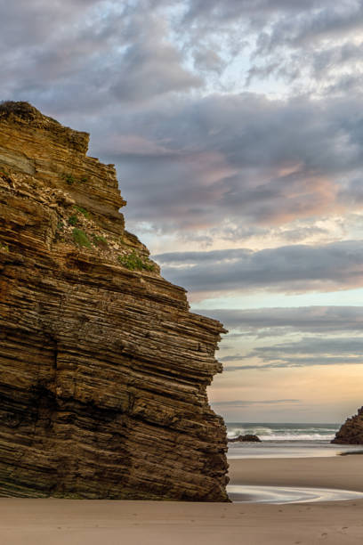 istock beautiful beach with fine sand and rocky cliffs at sunrise 1285874701