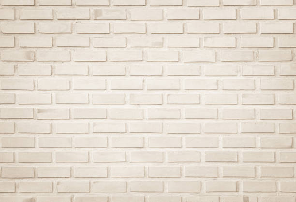 istock Empty Background of wide cream brick wall texture. Old brown brick wall concrete or stone pattern nature, wallpaper limestone abstract floor/Grid uneven interior rock. Home & office design backdrop. 1285878073