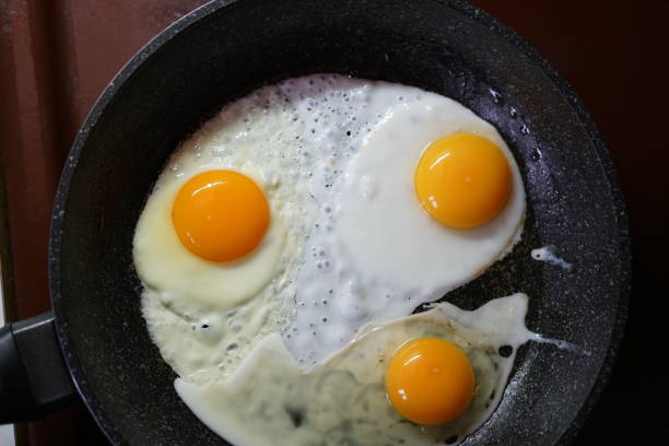 istock Fried eggs in a frying pan. Yellow yolks. 1285880636