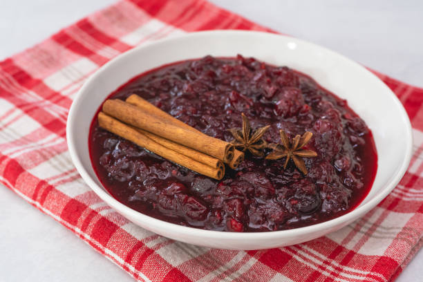 cranberry sauce, cinnamon, anise star close up in a bowl on kitchen table - jellied cranberries fotos imagens e fotografias de stock