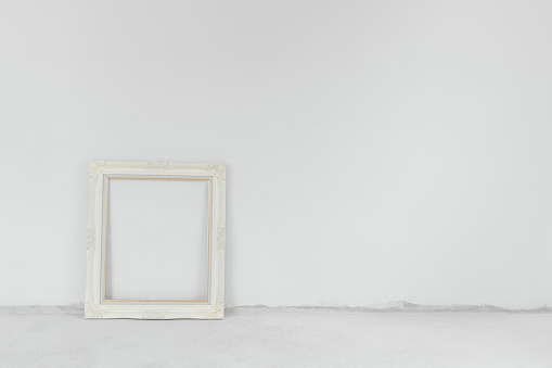 White wall and concrete cement floor, with vintage picture frame