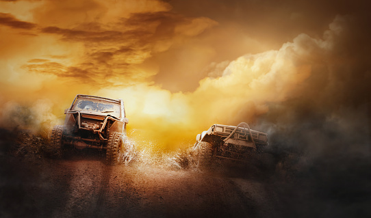 Two off road vehicles coming out of a mud hole hazard in off-road  competition.Background.