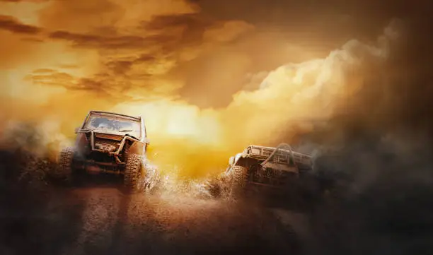 Two off road vehicles coming out of a mud hole hazard in off-road  competition.Background.