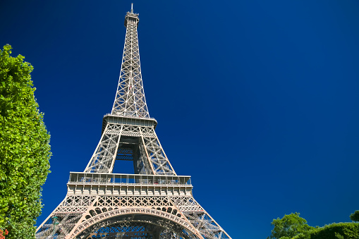 Paris, France - July 6, 2019:Architectural details of the Eiffel Tower at sunrise against a clear blue sky