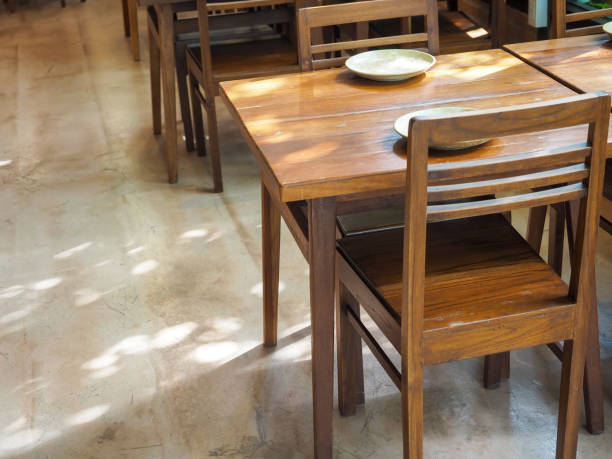 istock Simple wooden dining table with empty dish and wood chairs. 1285888741