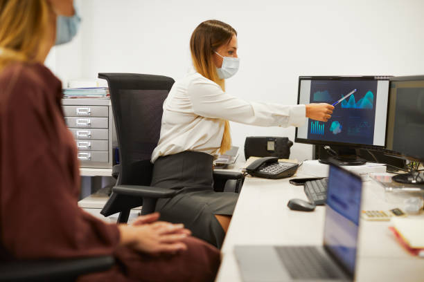 istock Two businesswoman sharing a computer monitor. 1285891419