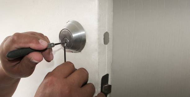istock closeup selective focus of locksmith hands using pick tools to open locked door - copyspace 1285894137