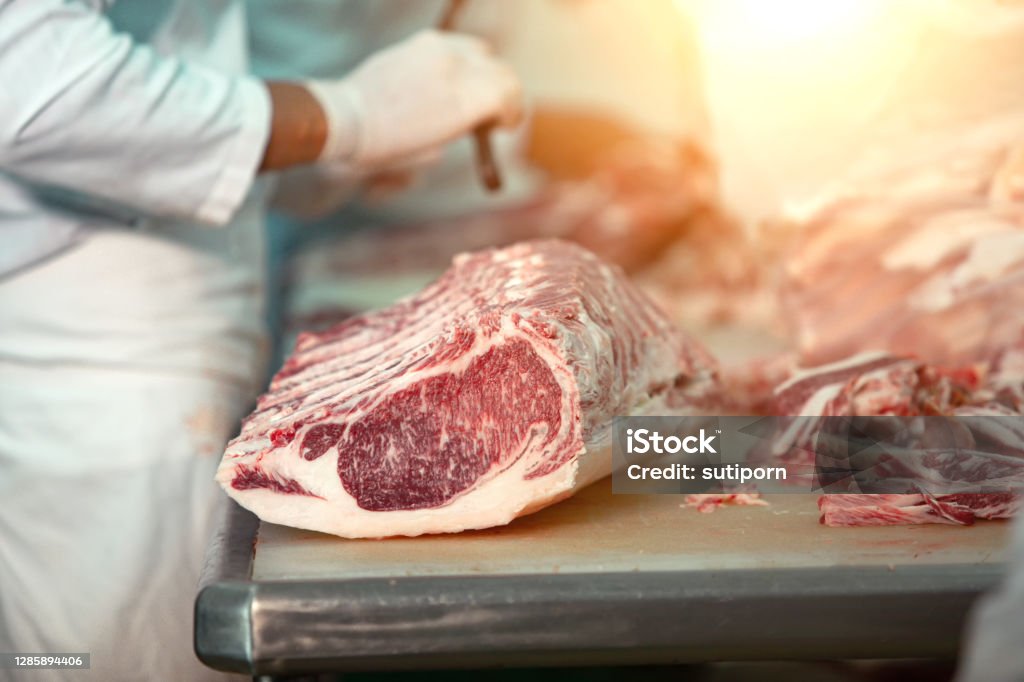 Butcher cutting wagyu beef in the Slaughterhouse Meat Packing Industry Stock Photo