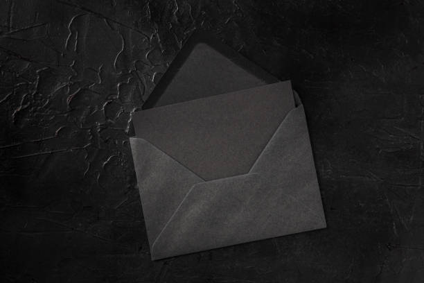 istock A black card in a black envelope mockup, shot from the top on a black background 1285895483