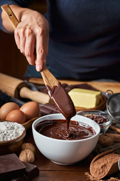 istock Woman hands making chocolate mousse and cookies on a wooden table in a rustic kitchen 1285898725