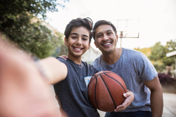 istock Hispanic father and son taking a selfie outdoors whilst playing basketball 1285898852