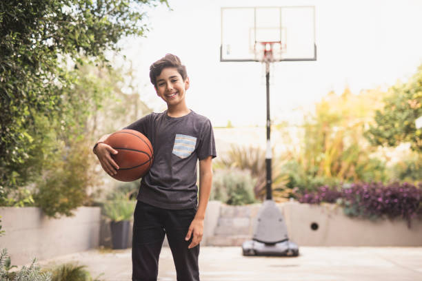 istock Portrait of a young hispanic boy standing outdoors with a basket 1285898902