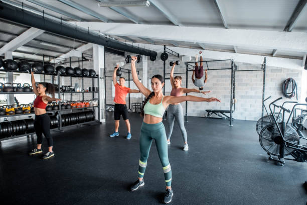 istock Mixed Race Young Woman Exercising With Friends Using Dumbbells 1285901372
