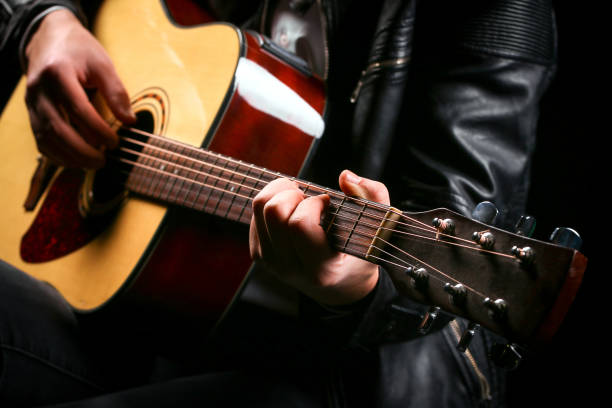 istock Young men playing the guitar with black background 1285901404