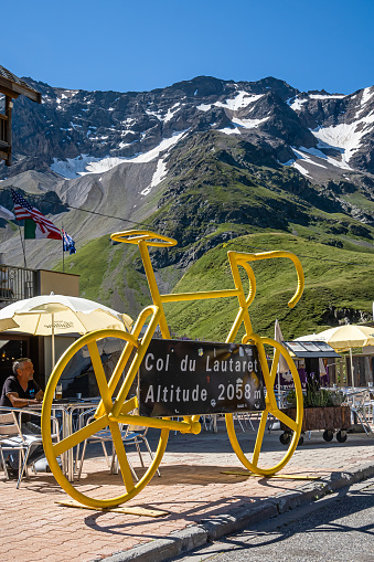 Col du Lautaret, France - July 8, 2020: Col du Lautaret is a french alpine mountain pass at 2642 metres. A yellow model bicycle.