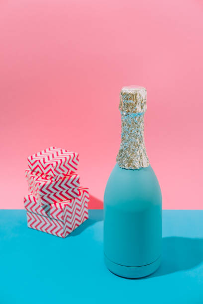 Abstract pastel colorful pink and blue backdrop with Champagne bottle with gift boxes. New Year Party Aesthetic.