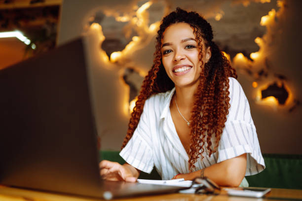 istock Young woman working online on laptop computer sitting in cafe. Freelancer working outside office. 1285904539