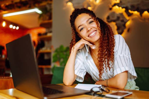 istock Young woman working online on laptop computer sitting in cafe. Freelancer working outside office. 1285904540