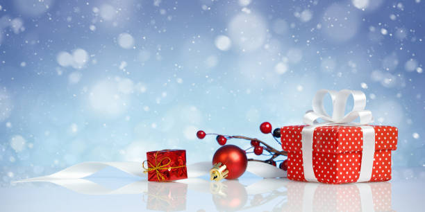 istock Red christmas gift box with decorations on blue background 1285908148