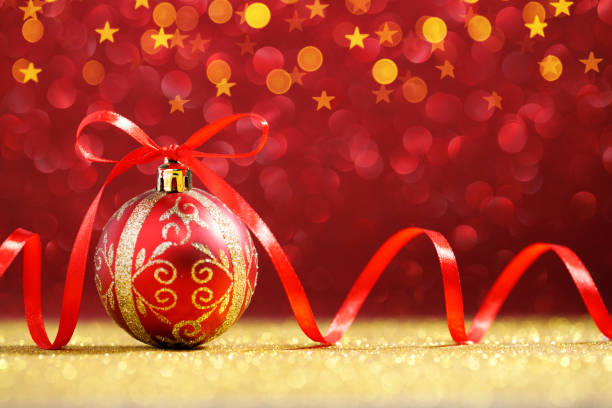 istock Red christmas ball with red bow on golden glitter 1285908191