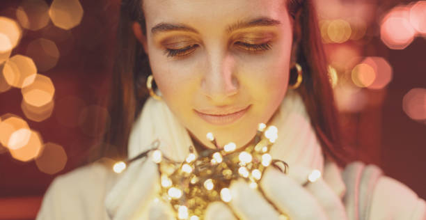 istock Happy woman holding Christmas lights 1285909464