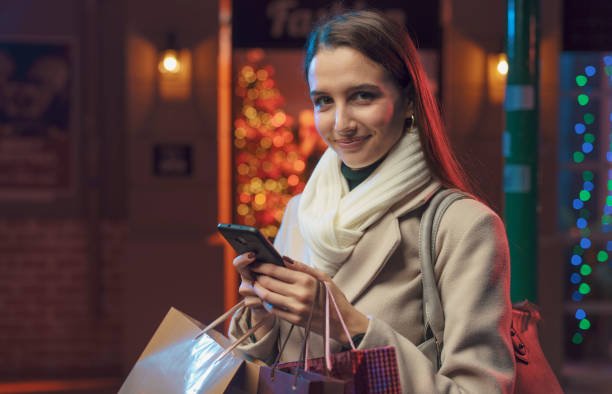 istock Happy woman doing Christmas shopping and using her smartphone 1285909569