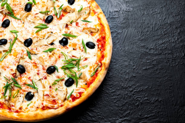 istock Pizza VENICE on a black background, tomato-based with mozzarella, grilled chicken, olives,green and onion. 1285912008