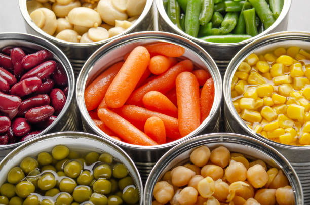 istock Canned vegetables in opened tin cans on kitchen table. Non-perishable long shelf life foods background 1285912173