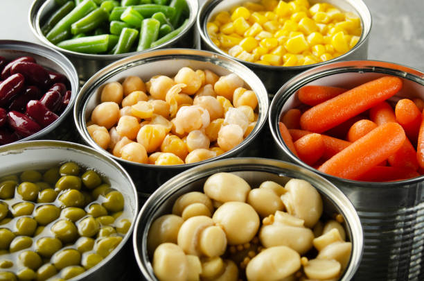 istock Canned vegetables in opened tin cans on kitchen table. Non-perishable long shelf life foods background 1285912202
