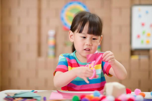 istock young girl using scissors cutting paper for making craft for home-schooling 1285913801