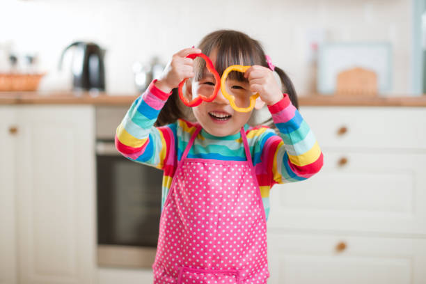 istock young girl put pepper ring on her face as glass against real kitchen background 1285914409