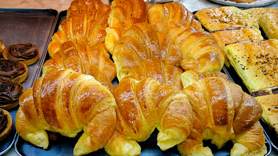 Heap of fresh baked French croissants on tray  ready to be sold. Bakery.cafeteria. Galicia Spain.