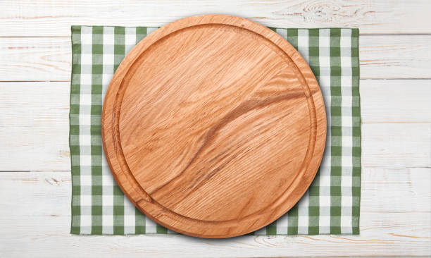 istock Empty pizza board and tablecloth on wooden deck table with napkin 1285915244