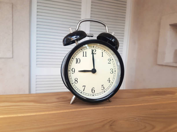 istock Vintage alarm clock, on wooden background 1285917797