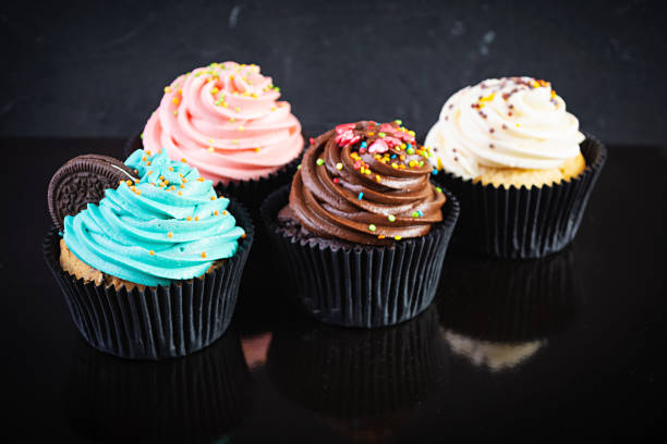 istock Tasty colorful cupcakes isolated on dark background. Delicious cupcake 1285918917