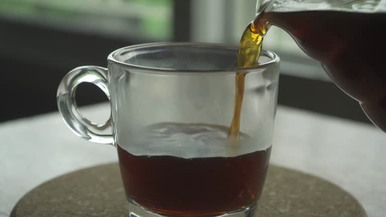 pouring coffee from carafe into a glass cup