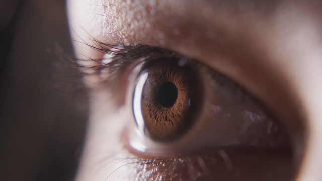 4k video footage of a teenage girl’s eye looking away against a black studio background