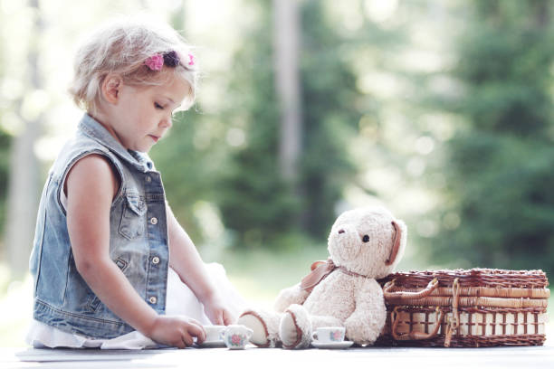 istock Girl playing with teddy bear 1285924374