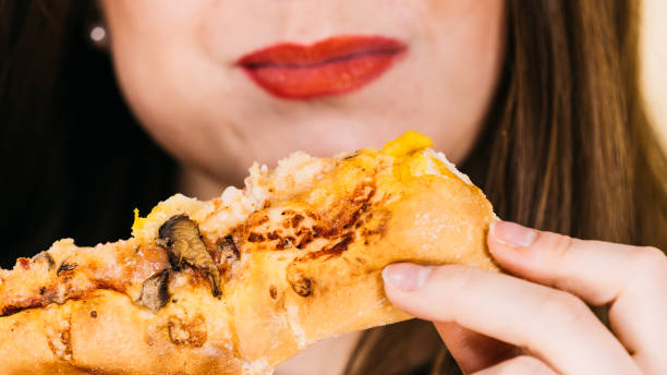 istock Woman eating hot pizza slice 1285924431