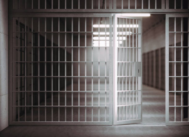 istock corridor of a prison with bars and open cell door. 1285924967