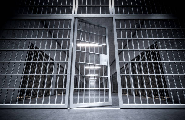 corredor de una prisión con barras y puerta de celda abierta. - jail fotografías e imágenes de stock