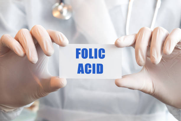 istock Doctor holding a card with text FOLIC ACID 1285925686