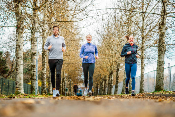 istock Friends jogging together against bare trees 1285928907