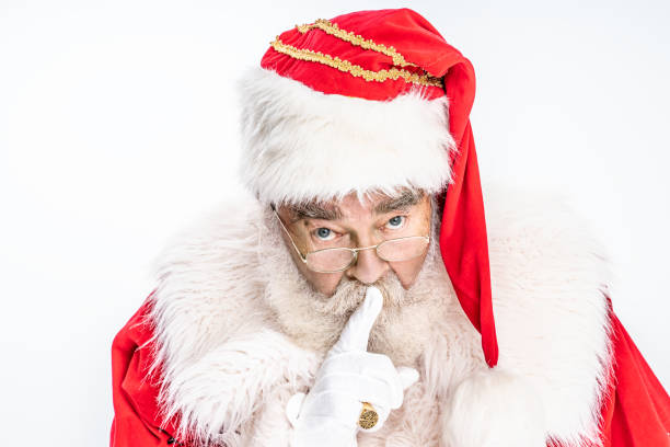 Santa Claus asking to be quiet,silence and secret concept. Portrait of real authentic Santa Claus with white beard and red hat asking to be quiet with finger on lips. silence and secret concept. santa claus expressions shhh stock pictures, royalty-free photos & images