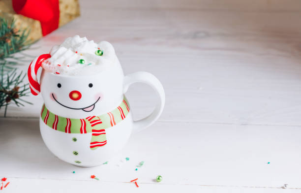 istock Hot chocolate in smiling snowman mug in Christmas setting 1285929785